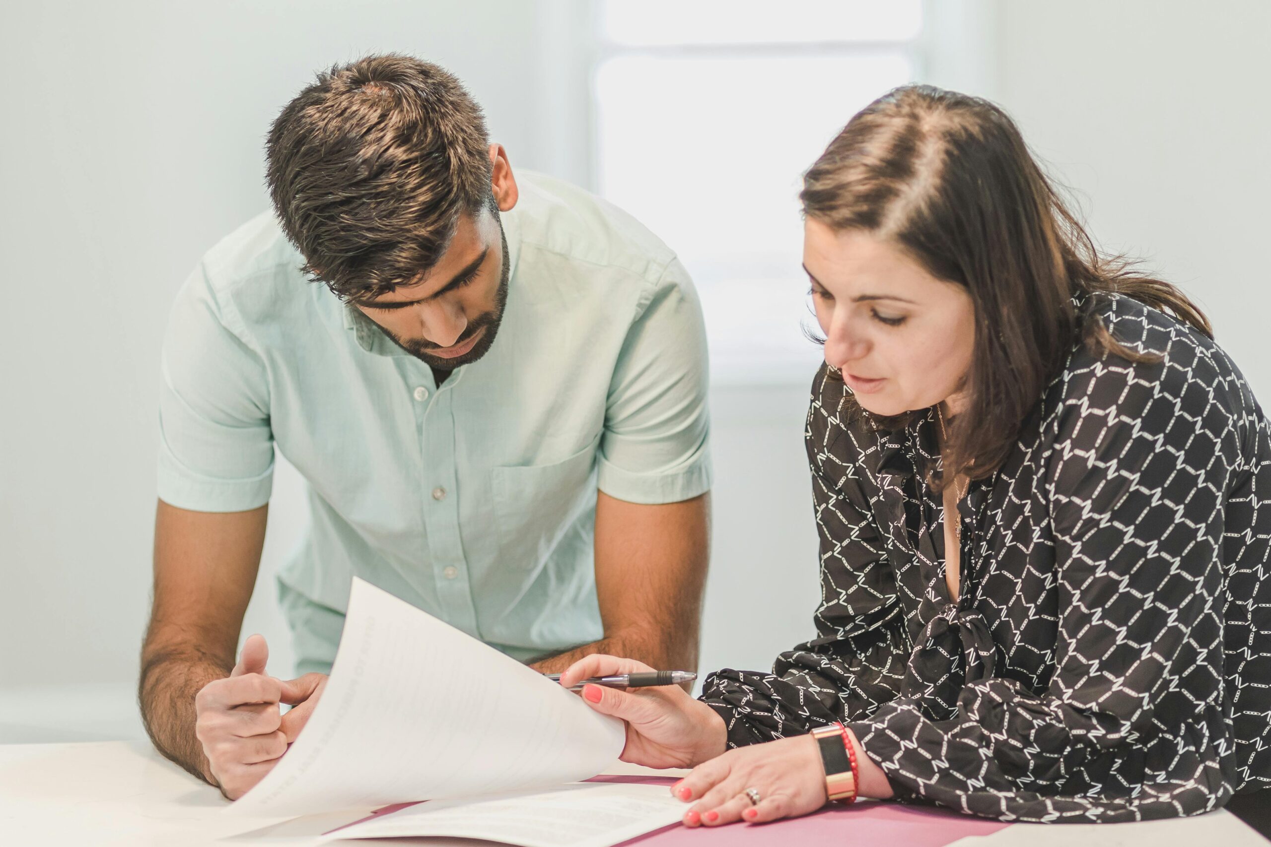 Services Real estate agent assisting first-time homebuyer with documents inside a bright room.
